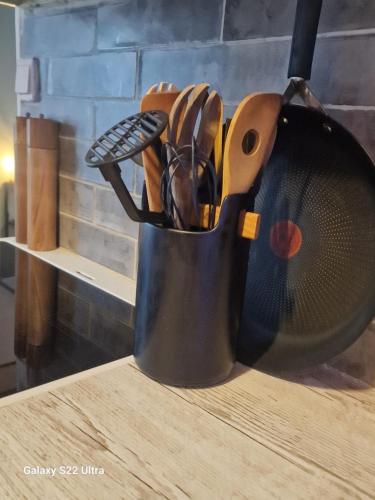 a metal cup filled with utensils on a table at Sjarmerende leilighet i hjerte av Tønsberg by in Tønsberg