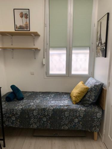 - un canapé dans une pièce avec 2 fenêtres dans l'établissement Paris Golden Studio, à Paris