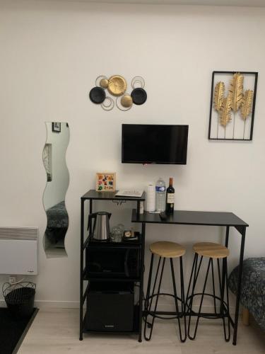 un bureau avec deux tabourets et un ordinateur sur un mur dans l'établissement Paris Golden Studio, à Paris