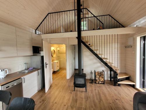 a kitchen and living room with a staircase in a house at APANÓWKA domki z balią jacuzzi sauna in Trzebiechowo
