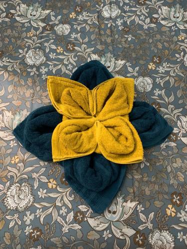 - une serviette bleue avec une étrave jaune sur un lit dans l'établissement Paris Golden Studio, à Paris