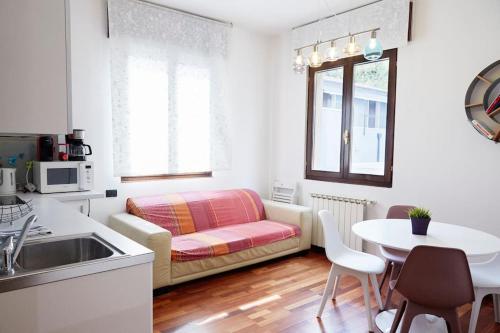 a kitchen and living room with a couch and a table at Venice-Flat 75m² perfect for 2 couples (free Park) in Mestre