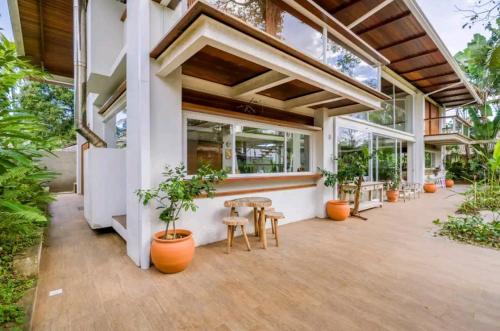 a building with tables and potted plants on a patio at Salt 'n Paradise Luxury Surf and Beach Suites in Ubatuba