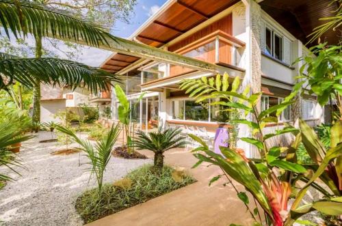 a tropical house with a lot of plants at Salt 'n Paradise Luxury Surf and Beach Suites in Ubatuba