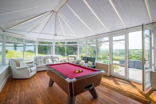 a room with a pool table in a conservatory at Blaenachddu in Capel-Ifan
