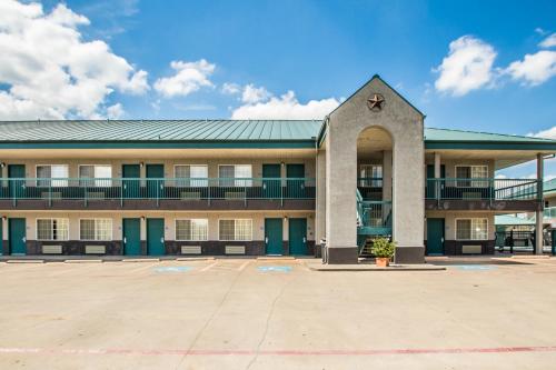 an empty parking lot in front of a building at Americas Best Value Inn Fort Worth in Fort Worth