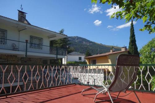 einen Stuhl auf dem Balkon eines Hauses in der Unterkunft SUYOLUCE, su chalet en la Sierra in El Escorial