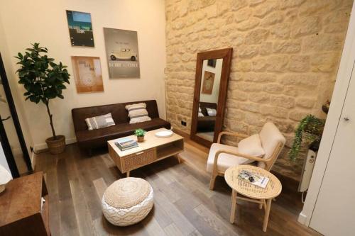 a living room with a couch and a table at Cosy 2 chambres / Père-Lachaise in Paris