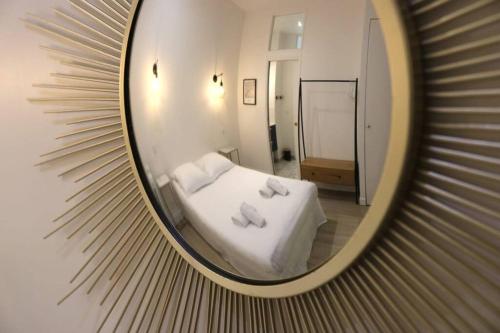 a mirror reflection of a bed in a room at Cosy 2 chambres / Père-Lachaise in Paris