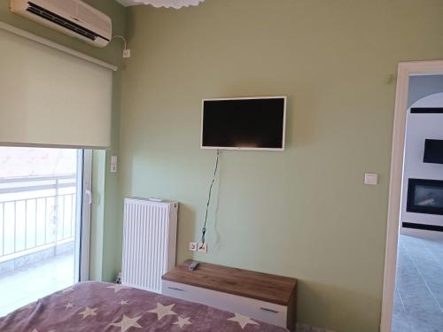 a bedroom with a bed and a tv on the wall at Rea's House Vrachati in Vrahati