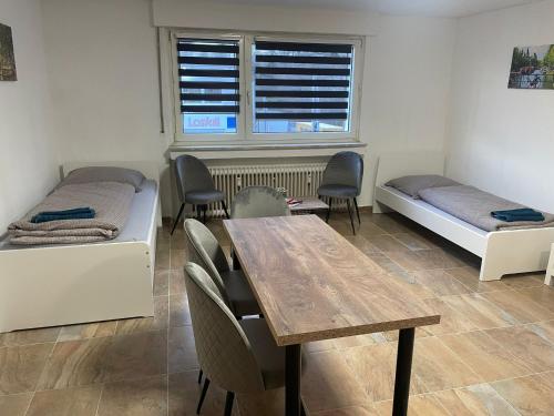 een kamer met 2 bedden en een tafel en stoelen bij estrella24 LIVING ROOMS Amsterdam in Castrop-Rauxel
