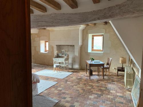 Cette chambre dispose d'un escalier avec une table et des chaises. dans l'établissement Château de la Faverie chambres d hôtes, à Beaumont-Pied-de-Boeuf