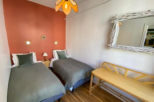 - 2 lits dans une chambre avec un miroir dans l'établissement Appartement historique cœur de ville, chic et cosy, à Rambouillet