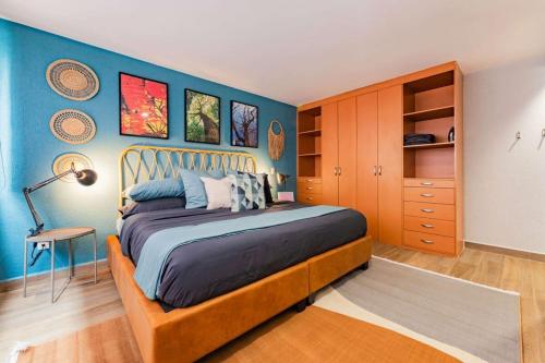 a bedroom with a bed and a blue wall at NEW Exciting Roma Condo Parque Mexico 550m Walk in Mexico City