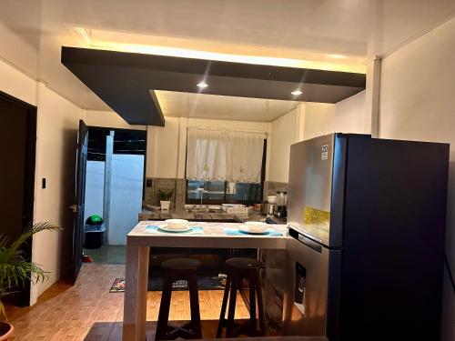 a kitchen with a table and a refrigerator at Casa caribes in Puerto Limón