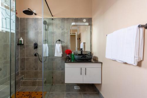 a bathroom with a glass shower and a sink at Serene, Escape Haven in Kileleshwa in Nairobi