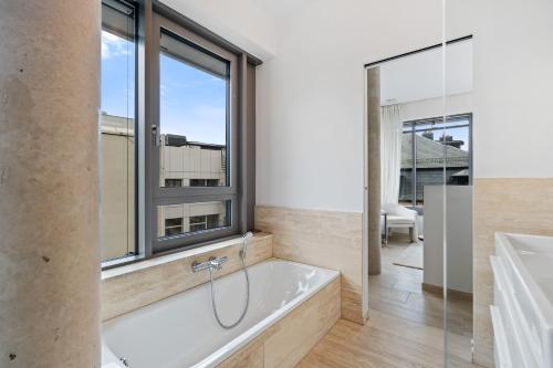 a bathroom with a bath tub and a window at Ville Haute Gem - Amazing City View ID175 in Luxembourg