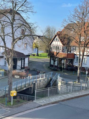 a bridge over a canal in a town with houses at Casa Bella in Guxhagen
