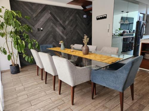 ein Esszimmer mit einem Glastisch und Stühlen in der Unterkunft Cozy room in big Apartmet in Mexiko-Stadt