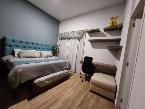 ein Schlafzimmer mit einem Bett mit einem blauen Kopfteil und einem Stuhl in der Unterkunft Cozy room in big Apartmet in Mexiko-Stadt