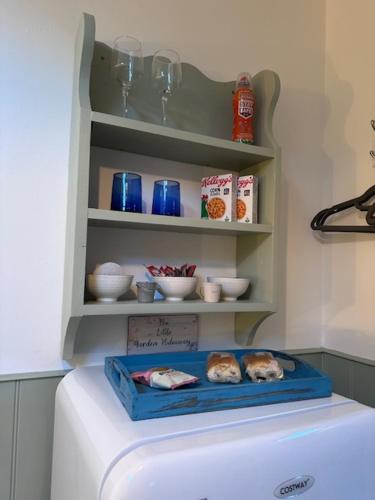 a white refrigerator in a kitchen with a shelf at The Little Garden Hideaway with Stunning Sea Views and Garden in Holyhead