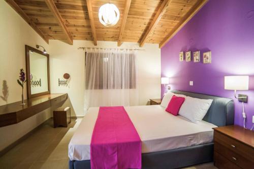 een slaapkamer met een groot bed met paarse muren bij Villa Lemonia Platanias in Plataniás