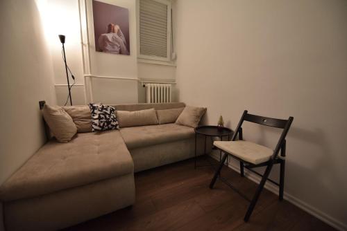 uma sala de estar com um sofá e uma cadeira em The Šljivka em Belgrado