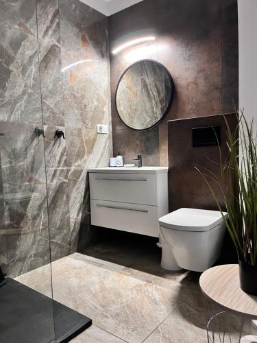 a bathroom with a toilet and a sink and a mirror at Apartament Przy Obserwatorium&Singielnia in Olsztyn