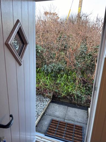 an open door with a view of a garden at The Little Garden Hideaway with Stunning Sea Views and Garden in Holyhead