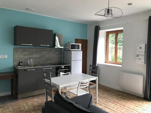 a small kitchen with a white table and a white table at Les Granges du Pichat in Froges