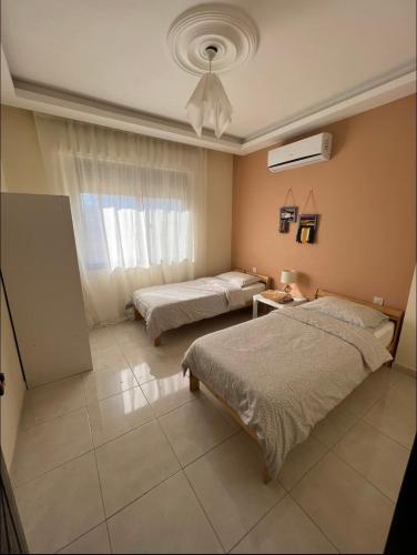 - une chambre avec 2 lits et une fenêtre dans l'établissement الراشد للشقق المفروشة, à Irbid