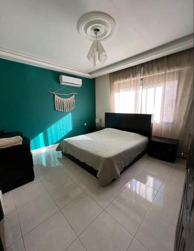 - une chambre avec un lit et un mur vert dans l'établissement الراشد للشقق المفروشة, à Irbid