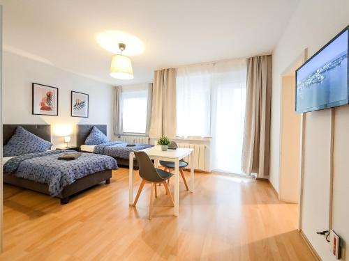 a living room with a bed and a table at Centerline Apartments Solingen in Solingen