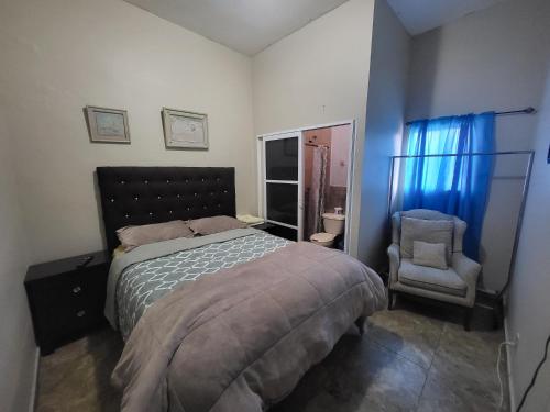 a bedroom with a bed and a chair at Departamentos velasco Planta baja in Tijuana