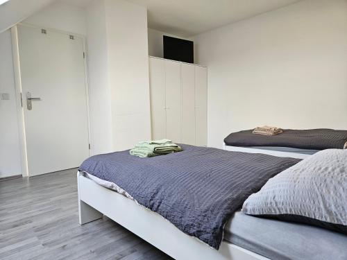 - une chambre avec 2 lits et des murs blancs dans l'établissement An der Dorfeiche, à Hamm