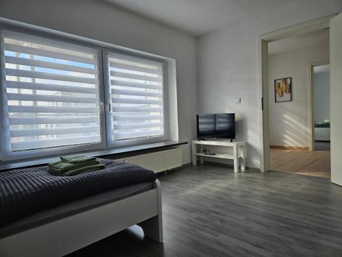 a bedroom with a bed and two large windows at An der Dorfeiche in Hamm
