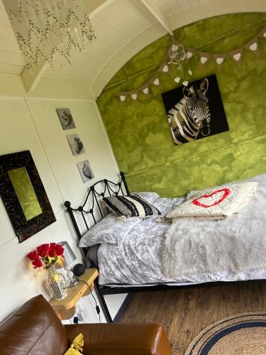 a bedroom with a bed with a zebra picture on the wall at Rhodes To Serenity - Mermaid Shepherds Hut in Stoke on Trent