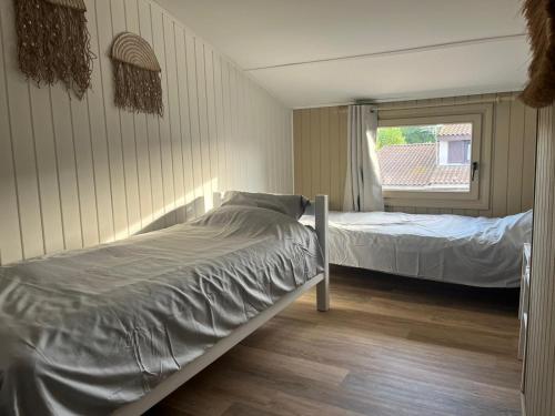 a bedroom with two beds and a window at Maison à Portiragnes Plage - Résidence les Tamaris - Porte du Soleil - Prix piscine comprise in Portiragnes