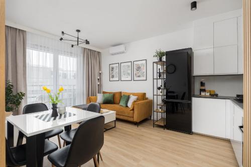uma cozinha e uma sala de estar com mesa e cadeiras em WARSZAWSKI SEN. Apartament na 5 em Varsóvia