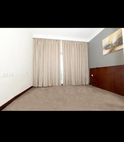 an empty room with a window and a curtain at Master room(for 1 lady or 2) in Dubai