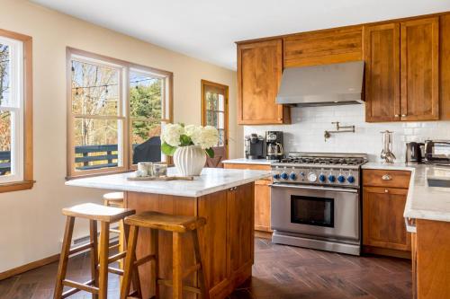 a kitchen with wooden cabinets and a stove at Catskills Delaware River Modern Colonial Getaway in Narrowsburg