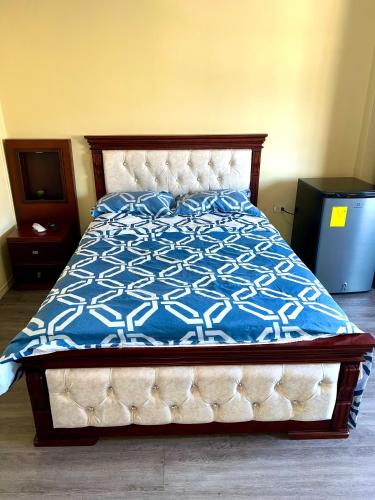 um quarto com uma cama com um edredão azul e branco em HABITACIÓN CENTRAL em Machala