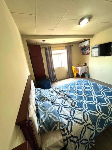um quarto com uma cama grande num quarto com uma mesa em HABITACIÓN CENTRAL em Machala