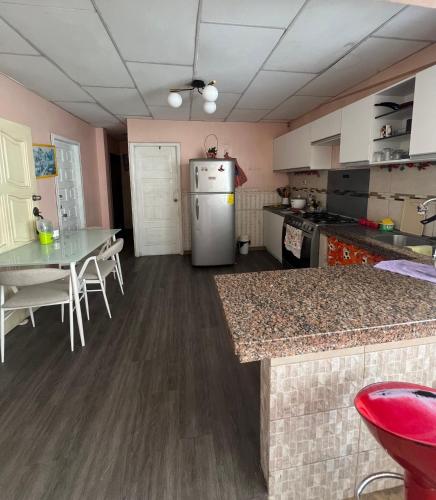 uma cozinha com um frigorífico e uma mesa em HABITACIÓN CENTRAL em Machala