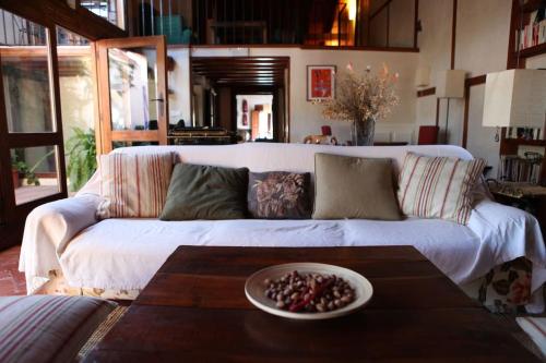 a living room with a white couch and a table at La Casa de las Pajaritas in Pasarón