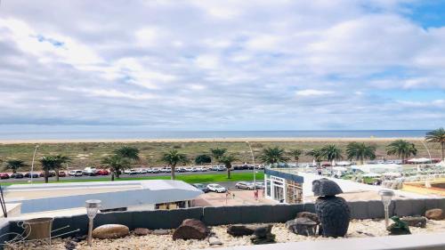 a person sitting on a wall looking at the beach at Zafiro Azul Powered by SolymarCalma in Morro del Jable