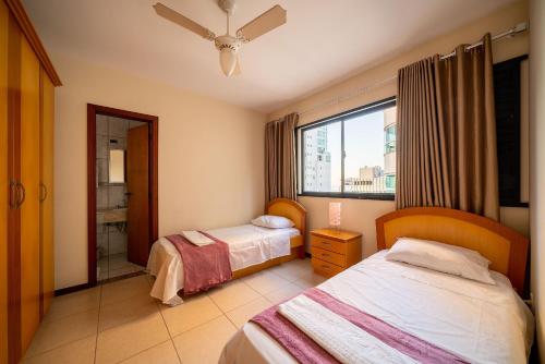 a hotel room with two beds and a window at Apto quadra mar c/varanda ESA901 in Balneário Camboriú