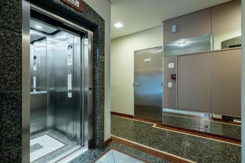 a elevator in a building with a glass door at Apto quadra mar c/varanda ESA901 in Balneário Camboriú