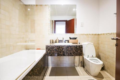 a bathroom with a tub and a toilet and a sink at Modern Oasis in Heart of Marina with Marina View - 11AB05 in Dubai