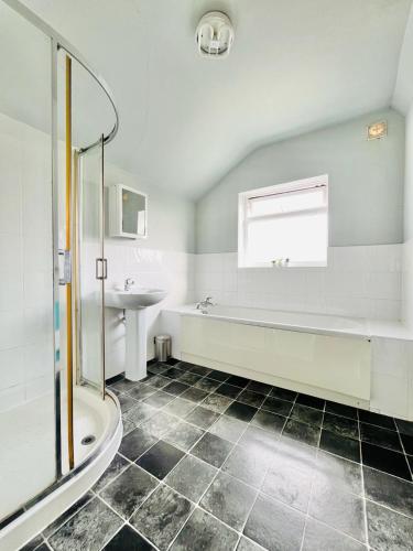 a bathroom with a shower and a tub and a sink at Luna Cottage - Grove Road Cottages in Stratford-upon-Avon